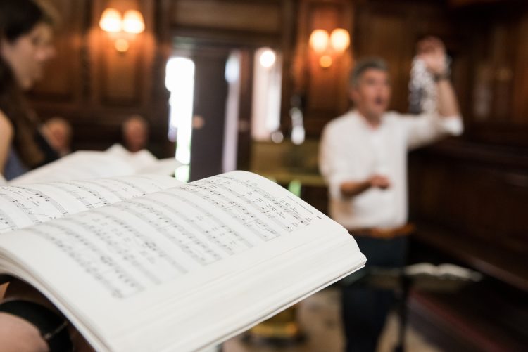 Music book in the Chapel with conductor in background Music book in the Chapel with conductor in background