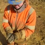 An archaeologist holding a Roman brooch