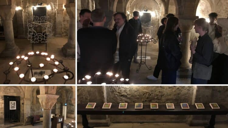 First-Year Fine Art Exhibition A church crypt with a variety of artworks on display and staff and students viewing the exhibits